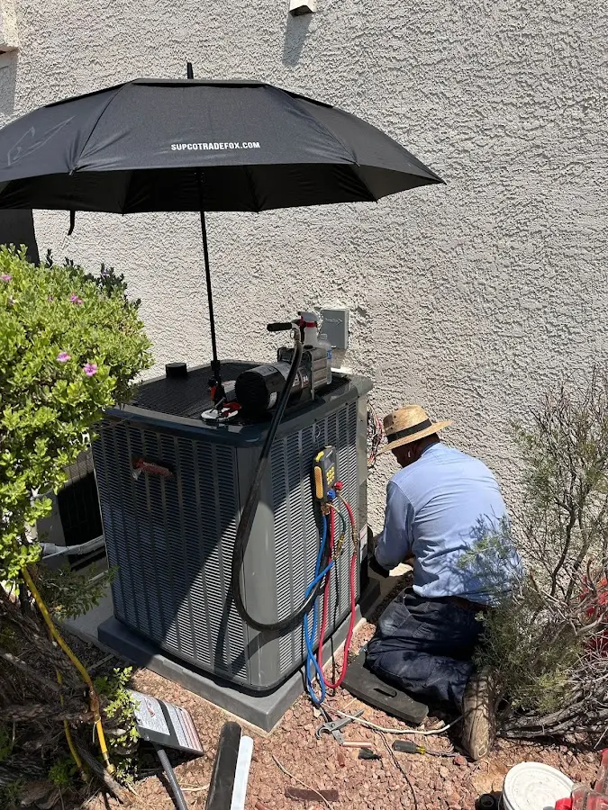 HVAC technician performing outdoor AC maintenance in Newbury