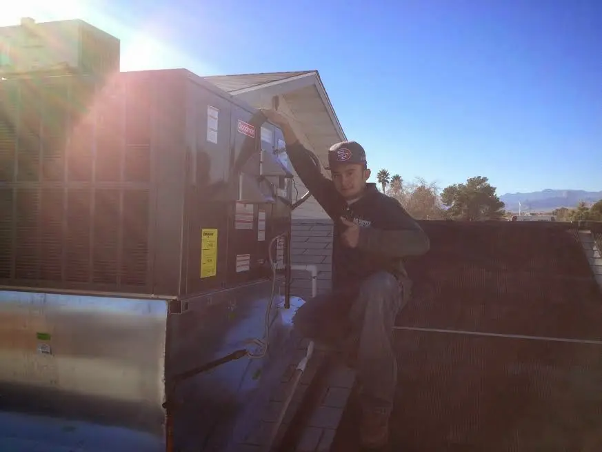 HVAC technician performing AC Tune-Up on a rooftop unit in Newbury